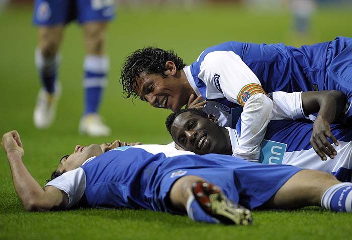 FC Porto´s forward from Colombia Radamel Falcao (L) celebrates with teammates forward Silvestre Varela (C) and defender Bruno Alves after scoring against Arsenal during their UEFA Champions League football match at the Dragao Stadium in Porto, on February 17, 2010. AFP PHOTO/MIGUEL RIOPA