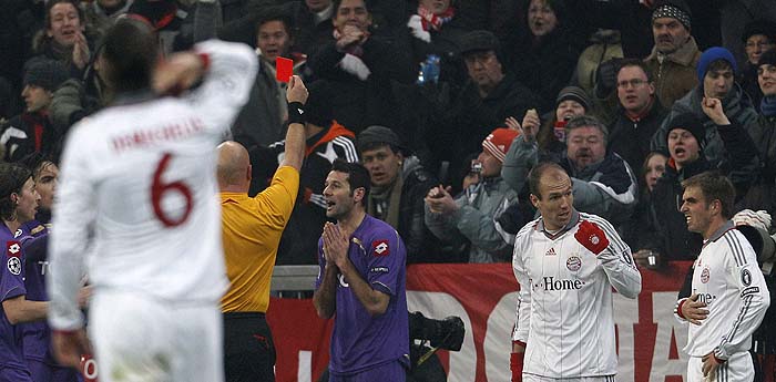 Fiorentina's Massimo Gobbi (3rd R) receives a red card from referee Tom Henning Ovrebo next to Bayern Munich's Arjen Robben (2nd R) and Philipp Lahm (R) during their Champions League soccer match in Munich February 17, 2010. REUTERS/Michaela Rehle (GERMANY - Tags: SPORT SOCCER)