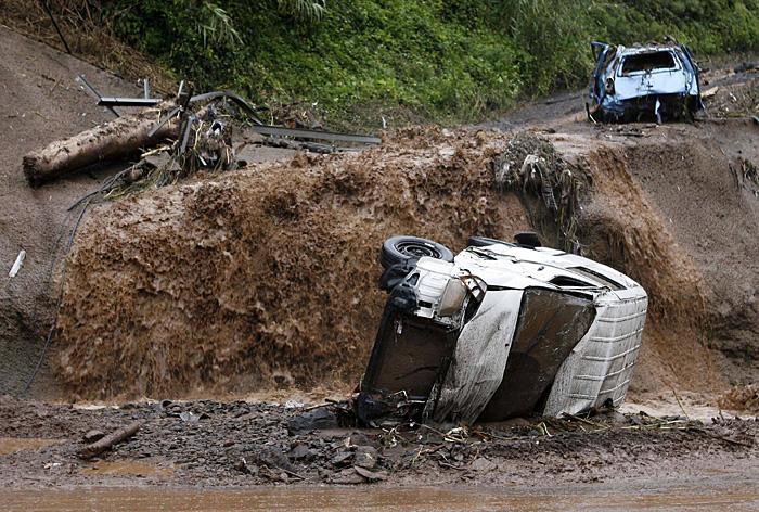 Destroyed vehicles and debris are seen on a road along the outskirts of Funchal, Madeira after heavy flooding, February 20, 2010. Fatalities have been reported from the floods and mudslides caused by torrential rains on Saturday on the Portuguese island of Madeira. REUTERS/Duarte Sa (PORTUGAL - Tags: DISASTER ENVIRONMENT SOCIETY TRANSPORT)