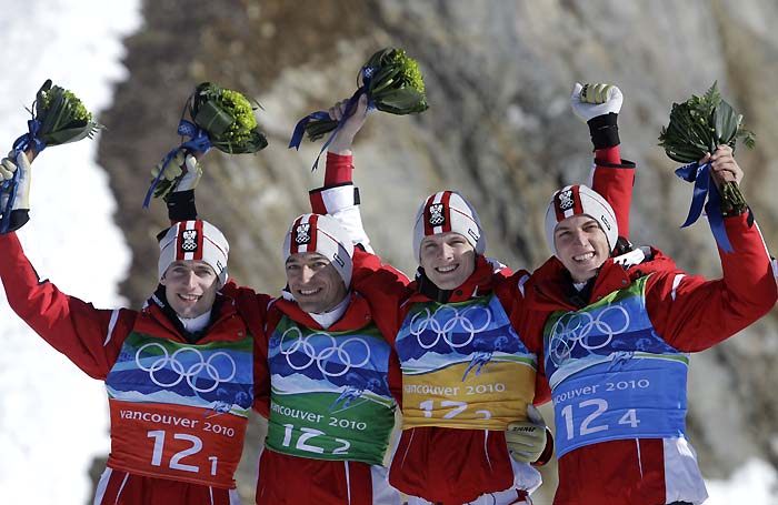 Austrian team, from left, Austria's Wolfgang Loitzl, Austria's Andreas Kofler, Austria's Thomas Morgenstern and Austria's Gregor Schlierenzauer celebrate winning the gold medal during the flower ceremony of the Men's ski jumping team event from the large hill at the Vancouver 2010 Olympics in Whistler, British Columbia, Canada, Monday, Feb. 22, 2010.(AP Photo/Elaine Thompson)