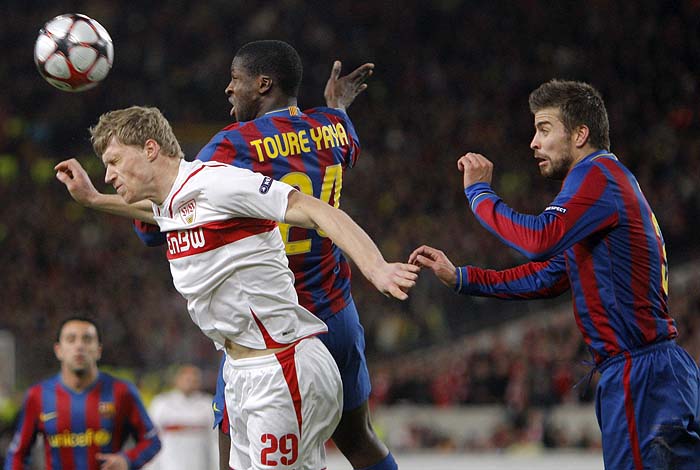 VfB Stuttgart's Pavel Pogrebnyak (L) and Barcelona's Yaya Toure fight for the ball during their Champions League soccer match in Stuttgart  February 23, 2010. REUTERS/Johannes Eisele (GERMANY - Tags: SPORT SOCCER)