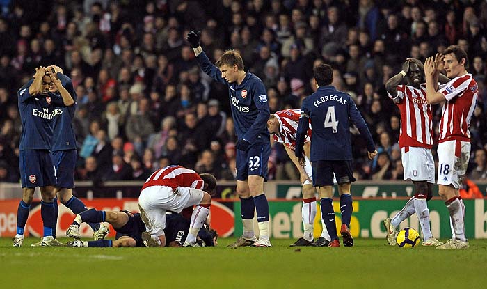 Stoke City's Irish player Glenn Whelan (3rd L) attends to Arsenal's Welsh midfielder Aaron Ramsey (2nd L) after he suffers a serious leg injury in a challenge with Stoke's English defender Ryan Shawcross (not pictured). Shawcross received a red card for the challenge from referee Peter Walton during the English Premier League football match between Stoke City and Arsenal at the Britannia Stadium, Stoke-on-Trent, Staffordshire, central midlands, England on February 27, 2010. AFP PHOTO/Paul EllisFOR EDITORIAL USE ONLY Additional licence required for any commercial/promotional use or use on TV or internet (except identical online version of newspaper) of Premier League/Football League photos. Tel DataCo +44 207 2981656. Do not alter/modify photo. 