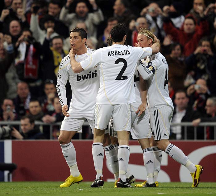 Real Madrid's Portuguese forward Cristiano Ronaldo (L) celebrates with teammates after scoring  against Olympique Lyon during their UEFA Champions League football match at the Santiago Bernabeu stadium in Madrid, on March 10, 2010. AFP PHOTO / PIERRE-PHILIPPE MARCOU