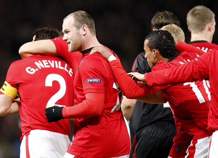 Manchester United's Wayne Rooney, second left, is congratulated by teammates after scoring a goal against AC Milan's during their Champions League first knockout round second leg soccer match at Old Trafford Stadium, Manchester, England, Wednesday March 10, 2010. (AP Photo/Antonio Calanni)