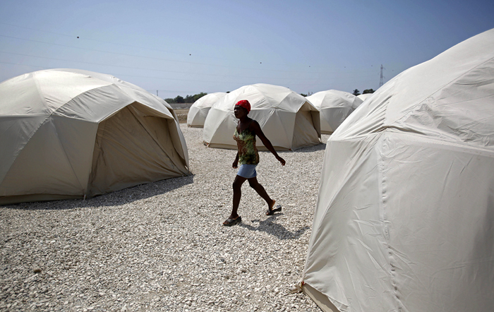 A woman walks between tents set up at a new camp for earthquake survivors in the Santo neighborhood in Port-au-Prince, Monday, March 15, 2010.  Authorities from the Dominican Republic are setting up the camp in their neighboring country, with tents provided by the International Organization for Migration, before the start of the upcoming rainy season. (AP Photo/Esteban Felix)
