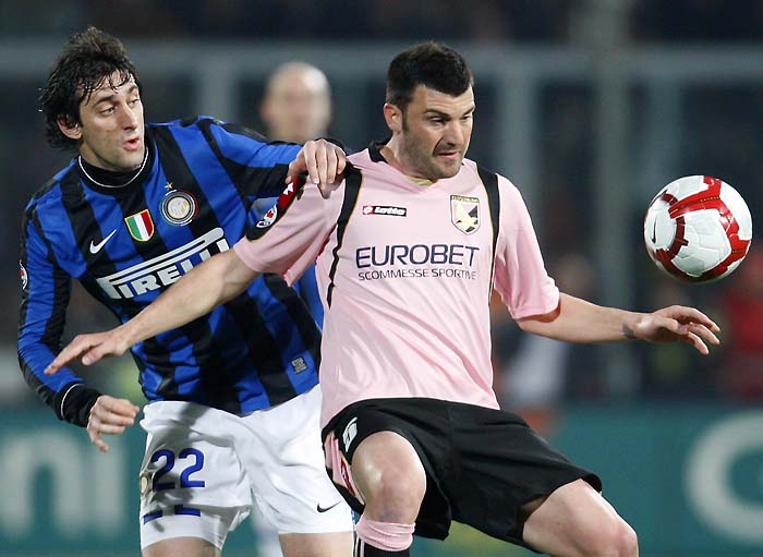 Inter Milan Argentine forward Diego Milito, left, challenges for the ball with Palermo defender Cesare Bovo during the Serie A soccer match between Palermo and Inter Milan, in Palermo, Italy, Saturday, March 20, 2010. (AP Photo/Antonio Calanni)