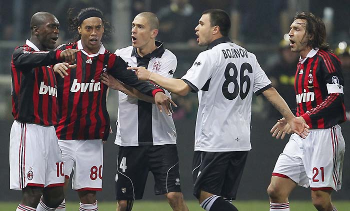 (from L to R), AC Milan's Clearance Seedorf of France, teammate brazilian Ronalinho, argue against Parma's Stefano Morrone and Valeri Bojinov of Congo during their series A soccer match at Ennio Tardini stadium in Parma, on March 24, 2010. AFP PHOTO / FABIO MUZZI