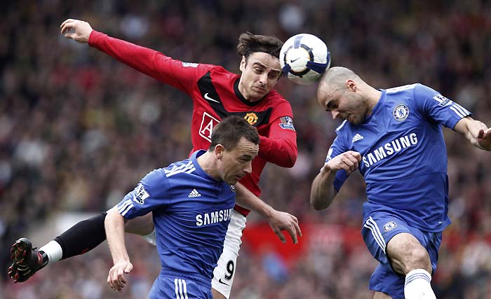 Manchester United's Dimitar Berbatov (top L) challenges Chelsea's John Terry (bottom L) and Alex (R) during their English Premier League soccer match at Old Trafford in Manchester northern England, April 3, 2010. REUTERS/Phil Noble (BRITAIN - Tags: SPORT SOCCER IMAGES OF THE DAY) NO ONLINE/INTERNET USAGE WITHOUT A LICENCE FROM THE FOOTBALL DATA CO LTD. FOR LICENCE ENQUIRIES PLEASE TELEPHONE ++44 (0) 207 864 9000