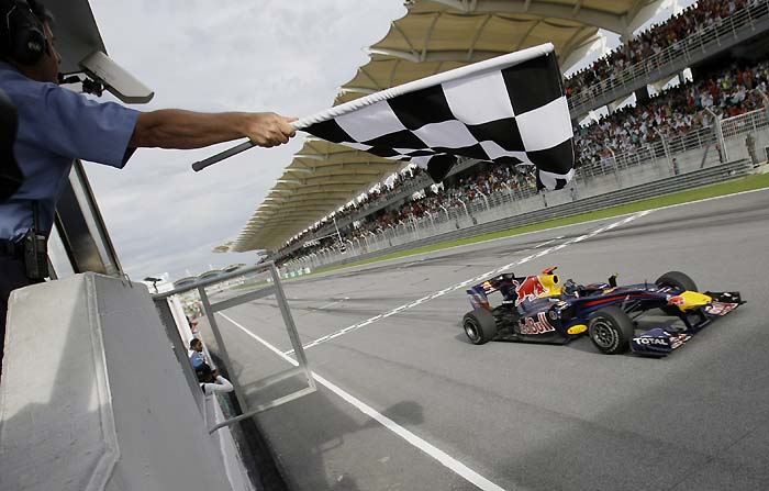 Red Bull Formula One driver Sebastian Vettel of Germany crosses the finish line to win the Malaysian Formula One Grand Prix in Sepang, Malaysia, Sunday, April 4, 2010. (AP Photo/Lee Jin-man)