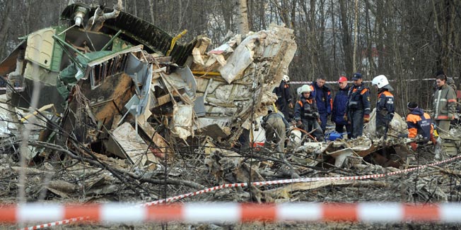 Russian rescuers (R) inspect the wreckage of a Polish government Tupolev Tu-154 aircraft which crashed on April 10 near Smolensk airport, on April 11, 2010. Appalling as it is, the plane tragedy that killed Poland's president is a potential game-changer in thorny Russian-Polish ties that may impact broader East-West relations in Europe, experts say. AFP PHOTO / NATALIA KOLESNIKOVA