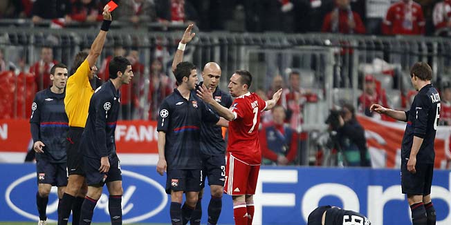 Referee Roberto Rosetti shows the red card to Franck Ribery (C red) of Bayern Munich during their Champions League semi-final first leg soccer match against Olympique Lyon in Munich April 21, 2010.    REUTERS/Michael Dalder (GERMANY - Tags: SPORT SOCCER IMAGES OF THE DAY)