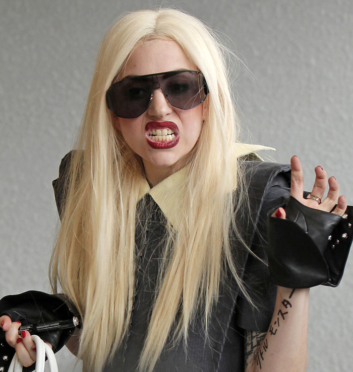 Singer Lady Gaga gestures on her arrival at the New Tokyo International Airport in Narita, east of Tokyo, for her Japan tour concerts in Kobe and Yokohama, Tuesday, April 13, 2010. The words written in Japanese on her arm read: 