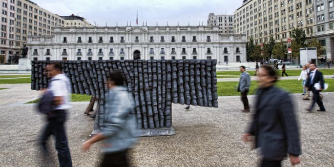 TO GO WITH AFP STORYPedestrians walk by a sculpture made by Chilean artist Federico Assler placed in front of La Moneda presidential palace in Santiago on April 20, 2010. Blind people have protested against the concrete T-form sculpture after some of them have bumped into it.  AFP PHOTO/Martin BERNETTI