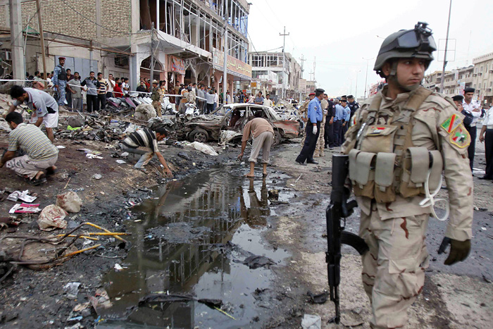 An Iraqi Army soldier stands guard at the site of a bombing in the southern Shiite port city of Basra, Iraq's second-largest city, 340 miles (550 kilometers) southeast of Baghdad, Iraq, Monday, May 10, 2010. Police said the southern city was hit with three bombings, which were the latest in a series of attacks killing nearly 100 across Iraq, the deadliest day this year. (AP Photo/ Nabil al-Jurani)    
