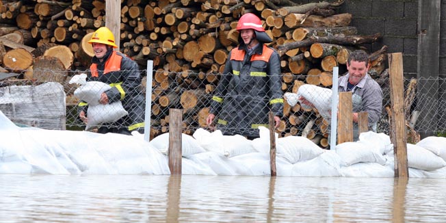 Babina Greda, 020610.Poplava u Babinoj Gredi. Izlila se rijeka Berava, izgradjeno je 100-ak metara nasipa od vreca napunjenih pijeskom, a zbog nepropusnih kanala plivala su i dvorista. Na fotografiji: vatrogasci DVD B. Greda pomazu seljanima u borbi s vodom.Foto: Damir Glibusic / CROPIX