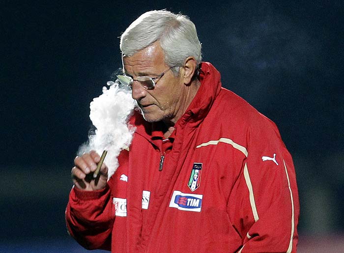 Italy's coach Marcello Lippi puffs a cigar as he walks off the pitch after a friendly match between the Italian team and Gauteng All Stars,  at the Southdowns Hill College in Irene, near Pretoria, Friday, June 11, 2010. Italy will play in group F at the Soccer World Cup. (AP Photo/Alessandra Tarantino)