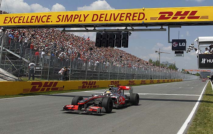 McLaren Formula One driver Lewis Hamilton of Britain crosses the finish line to win the Canadian F1 Grand Prix in Montreal June 13, 2010. REUTERS/Mathieu Belanger (CANADA - Tags: SPORT MOTOR RACING)