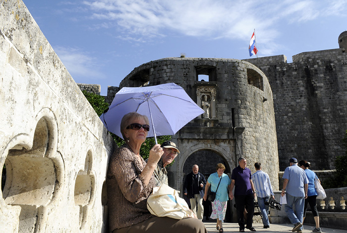 Dubrovnik, 251009.Lijepo vrijeme koje je danas na dubrovackom podrucju, brojnim turistima pruzilo je dodatnu lijepotu razgledavanja stare dubrovacke jezgre, gospodji na slici kisobran je ovoga puta posluzio kao zastita od sunca, a ne od kise koja je prosli tjedan padala u velikim kolicinama. Na slici: ulaz u staru dubrovacku jezgru sa Pila.Foto: Admir Buljubasic / CROPIX