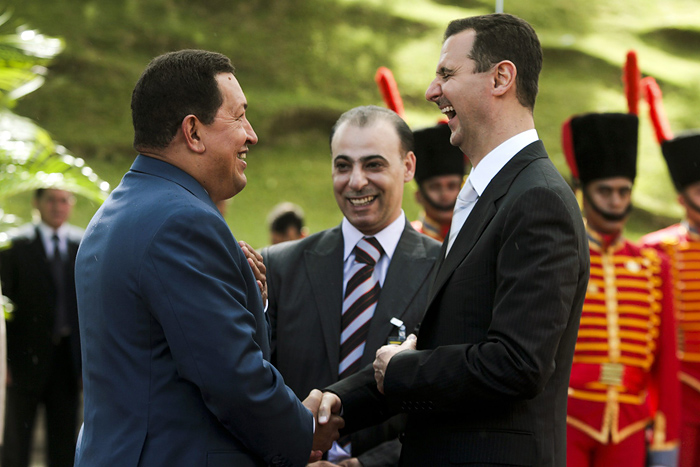 Syria's President Bashar al-Assad (R) shares a laugh with his Venezuelan counterpart Hugo Chavez (L), while they shake hands at Miraflores Palace in Caracas June 26, 2010. Picture taken June 26. REUTERS/Miraflores Palace/Handout (VENEZUELA - Tags: POLITICS) FOR EDITORIAL USE ONLY. NOT FOR SALE FOR MARKETING OR ADVERTISING CAMPAIGNS