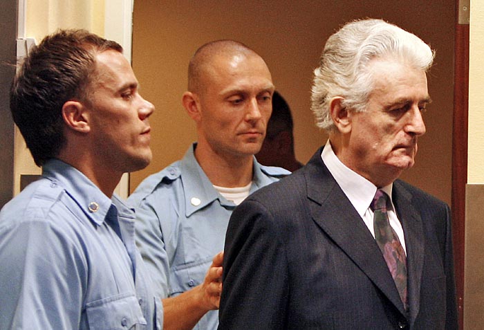 FILES-This file picture shows former Bosnian Serb leader Radovan Karadzic (R) entering the court room of the International Criminal Tribunal for the Former Yugoslavia (ICTY) at the start of his initial appearance on July 31, 2008 in The Hague. Bosnian Serb wartime leader Radovan Karadzic, 64, is set to go on trial on October 26, 2009 on 11 counts of genocide, war crimes and crimes against humanity. He is charged as one of the alleged authors of a plan to 