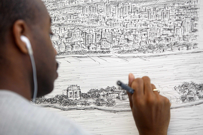British artist Stephen Wiltshire works on a hand-drawn panorama of the skyline of New York, from a studio at the Pratt Institute in Brooklyn October 28, 2009. The 18 foot (5.5 m) long panorama is being drawn from memory and will be displayed in the London gallery, which has similar drawings Wiltshire drew of Tokyo, Hong Kong, Rome, Madrid, Frankfurt, Dubai and Jerusalem.  REUTERS/Chip East (UNITED STATES SOCIETY ENTERTAINMENT)