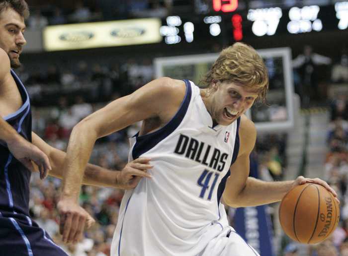 Utah Jazz center Mehmet Okur, left, from Turkey defends against Dallas Mavericks forward Dirk Nowitzki (41) from Germany as he drives to the basket in the second half of an NBA basketball game in Dallas, Tuesday, Nov. 3, 2009. The Mavericks won 96-85.  (AP Photo/Donna McWilliam)