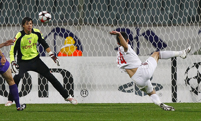 Debrecen's Gergley Rudolf (R) shoots to score as Fiorentina's goalkeeper Vlada Avramov (L) tries to stop him during their Champions League soccer match at the Artemio Franchi stadium in Florence November 4, 2009. REUTERS/Alessandro Bianchi   (ITALY SPORT SOCCER)