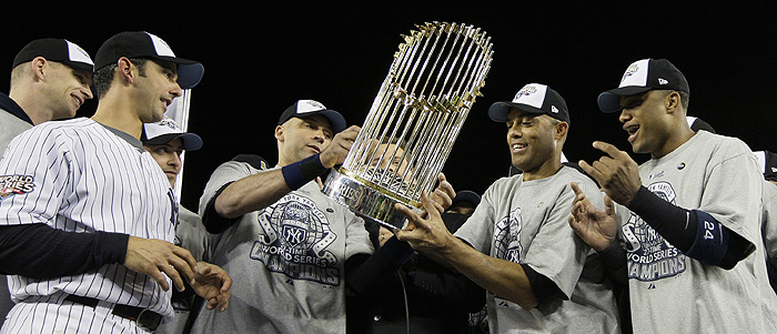 From left, New York Yankees' A.J. Burnett, Jorge Posada, Derek Jeter, Mariano Rivera and Robinson Cano examine the World Series trophy after winning the Major League Baseball World Series against the Philadelphia Phillies Wednesday, Nov. 4, 2009, in New York. (AP Photo/David J. Phillip) (AP Photo/David J. Phillip) 