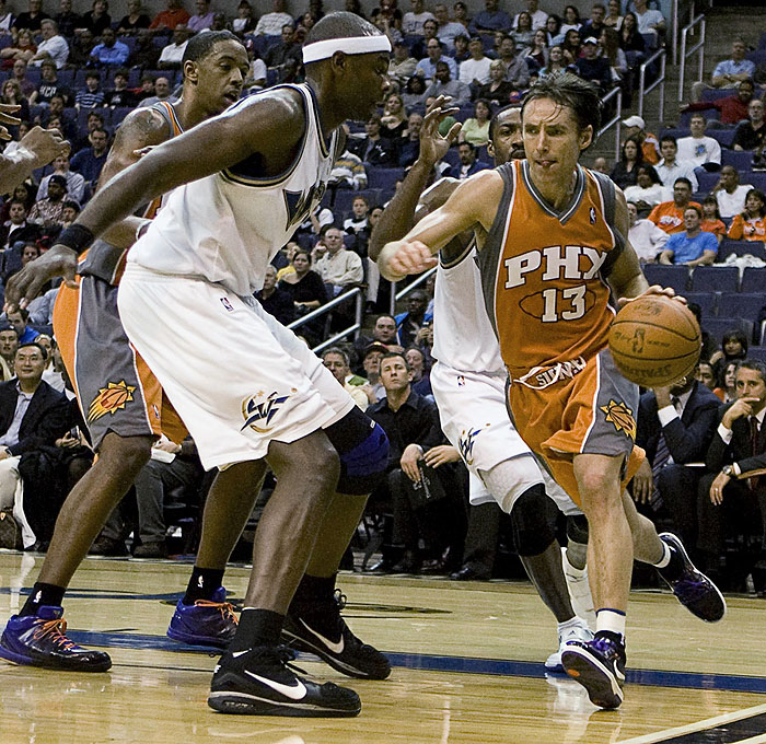 Phoenix Suns' Steve Nash (13) drives past Washington Wizards' Brendan Haywood (L) during the second quarter of their NBA game in Washington, November 8, 2009. REUTERS/Stelios Varias (UNITED STATES SPORT BASKETBALL)