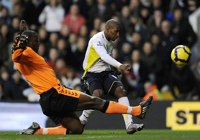 Tottenham Hotspurs' Jermain Defoe (C) shoots past Wigan Athletic's Titus Bramble (L) during the Premiership match at White Hart Lane in London on November 22, 2009. Tottenham  won the game 9-1 with Jermain Defoe scoring five second-half goals as Tottenham humiliated Wigan to record their highest top-flight win. AFP PHOTO / Adrian DennisFOR EDITORIAL USE ONLY Additional licence required for any commercial/promotional use or use on TV or internet (except identical online version of newspaper) of Premier League/Football League photos. Tel DataCo +44 207 2981656. Do not alter/modify photo.