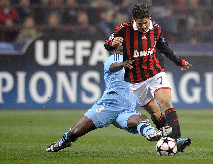A.C. Milan's Brazilian forward Pato (front) fights for the ball with Olympique de Marseille's Nigerian defender Taye Taiwo during their UEFA Champions League group stage football match on November 25, 2009 at San Siro stadium in Milan. AFP PHOTO / Damien Meyer
