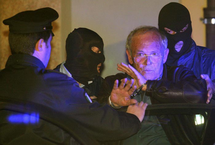 Masked Italian police officers accompany Mafia suspect Gaetano Fidanzati (2nd R) to a police station in Milan December 5, 2009. Fidanzati, who was on Italy's most wanted list, was captured on the same day that Giovanni Nicchi was arrested in the second major success against organised crime in less than a month, officials said. Interior Minister Roberto Maroni said police believed that Nicchi took over as the Mafias number two last month after the arrest of Domenico Raccuglia, who had been on the run for nearly 15 years.   REUTERS/Tommaso Balestra      (ITALY CRIME LAW)