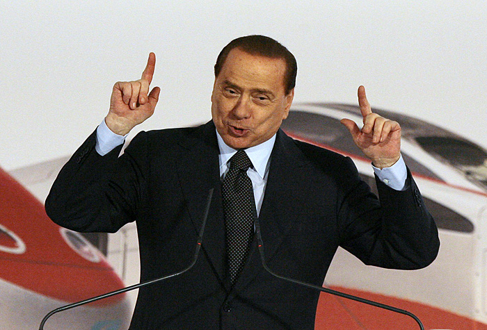 Italy's Prime Minister Silvio Berlusconi gestures as he speaks during a ceremony at the Centrale rail station in Milan December 5, 2009. Berlusconi marked a test trip on the high-speed-train Frecciarossa 