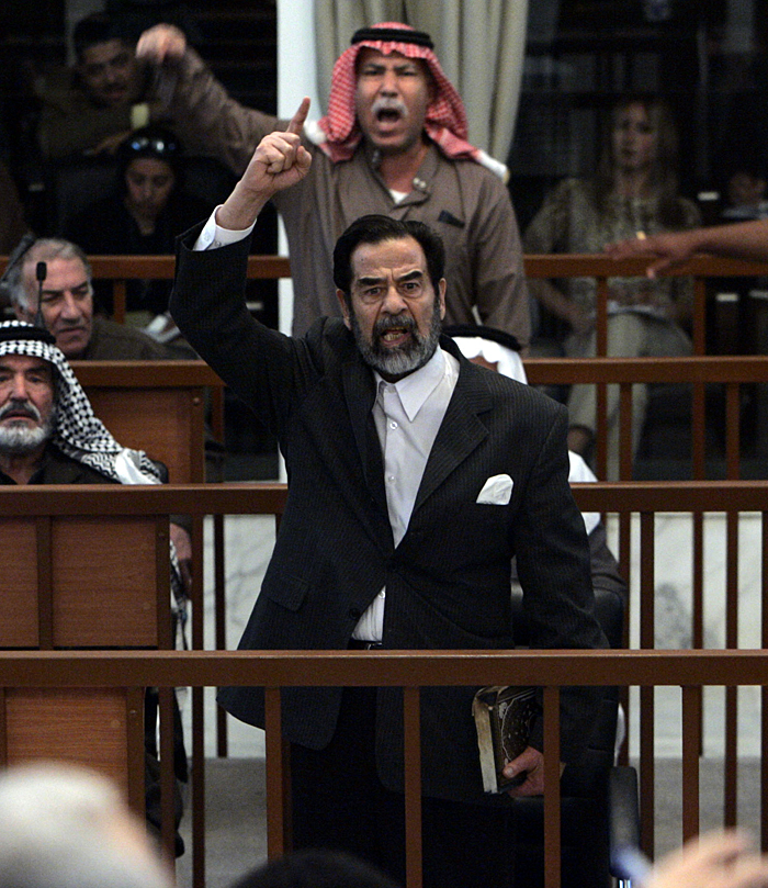 ** FOR USE AS DESIRED, PHOTOS OF THE DECADE ** FILE - Former Iraqi President Saddam Hussein, front center, and Barzan Ibrahim al-Tikriti, back center, berate the court during their trial in Baghdad, in this Dec. 5, 2005, file photo.    (AP Photo/David Furst, Poo, File)  