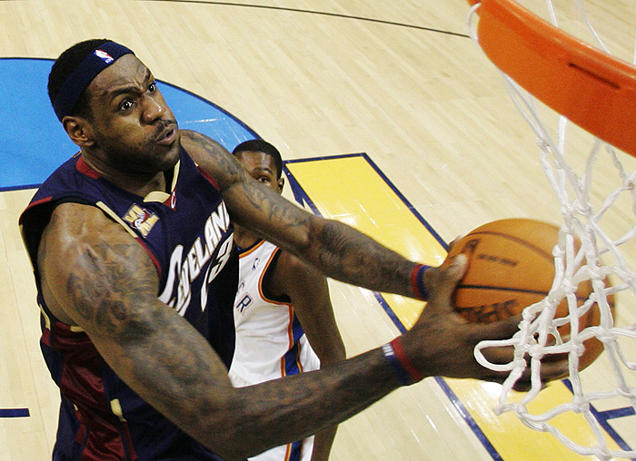 Cleveland Cavaliers forward LeBron James dunks in front of Oklahoma City Thunder forward Kevin Durant, rear, in the second quarter of an NBA basketball in Oklahoma City, Sunday, Dec. 13, 2009. James had 44 points as Cleveland won the game 102-89. (AP Photo/Sue Ogrocki)