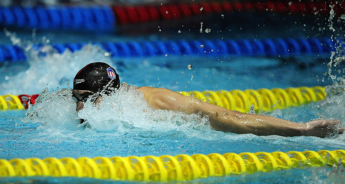 Michael Phelps of the U.S. swimming team competes in the men's 100m butterfly race during the Duel in the Pool competition at the Manchester Aquatics Centre in northern England December 18, 2009.  REUTERS/Dylan Martinez      (BRITAIN - Tags: SPORT SWIMMING)