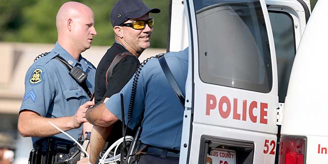 FERGUSON, MO - AUGUST 18: Getty Images staff photographer Scott Olson is placed into a paddy wagon after being arrested by police as he covers the demonstration following the shooting death of Michael Brown on August 18, 2014 in Ferguson, Missouri. Protesters have been vocal asking for justice in the shooting death of Michael Brown by a Ferguson police officer on August 9th.   Joe Raedle/Getty Images/AFP== FOR NEWSPAPERS, INTERNET, TELCOS & TELEVISION USE ONLY ==