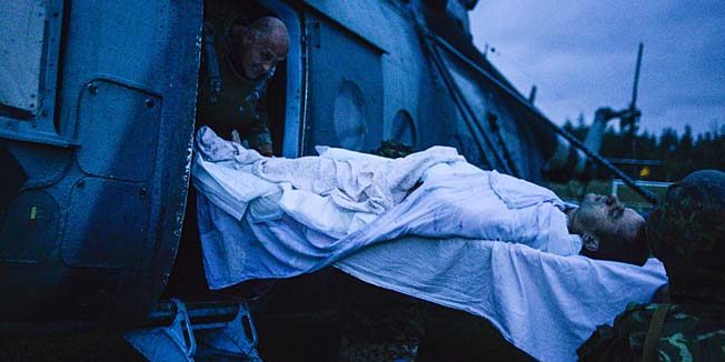 Ukrainian soldiers load a wounded man aboard a helicopter, near the eastern Ukrainian city of Shchastya, Lugansk region, on August 18, 2014. Ukraine accused pro-Russian rebels of killing dozens of civilians fleeing the war-torn east on August 18, 2014 as crisis talks between Kiev and Moscow failed to halt months of bloodshed.  AFP PHOTO/  ALEKSEY CHERNYSHEV