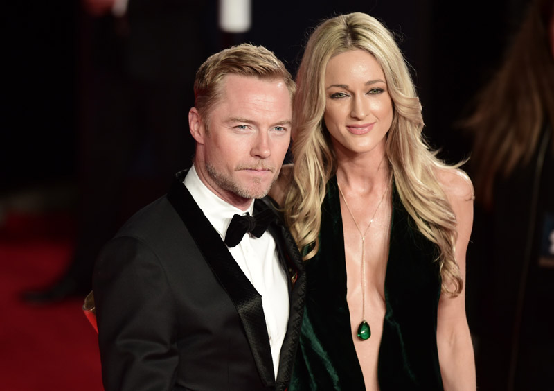 British singer Ronan Keating (L) and Storm Uechtritz pose on arrival for the world premiere of the new James Bond film 'Spectre' at the Royal Albert Hall in London on October 26, 2015. The film is directed by Sam Mendes and sees Daniel Craig play suave MI6 spy 007 for a fourth time. AFP PHOTO / LEON NEAL