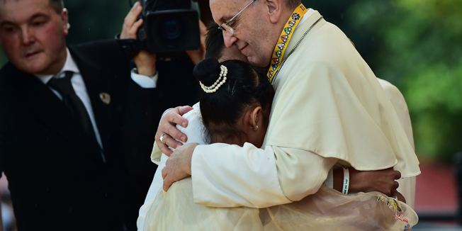 TOPSHOTSCORRECTION-ADDING NAMEPope Francis (R) embraces two children, including 12-year-old Glyzelle Palomar (2nd R), during his visit to the University of Santo Tomas in Manila on January 18, 2015.  Pope Francis will celebrate mass with millions in the Philippine capital on January 18 in what could be the world's biggest papal gathering, capping off a dramatic trip in the Catholic Church's Asian heartland.   AFP PHOTO / GIUSEPPE CACACE