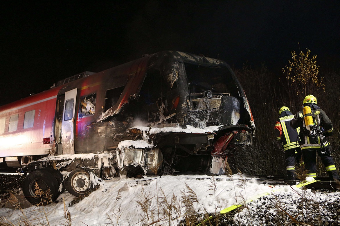 Rescuers gather at a partially burnt regional train after an accident on the railway near the Bavarian city of Freihung, southern Germany, on late November 5, 2015. An explosion occurred at the site after the collision between the train and a truck on a level crossing, with passengers being severely wounded and at least one dead.AFP PHOTO / DPA / NEWS5 / GRUNDMANN +++ GERMANY OUT
