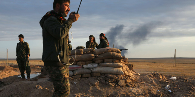 Fighters from the Syrian Democratic Forces (SDF), which includes Kurds, Arabs and Syriac Christians, monitor the countryside of the northeastern town of Al-Hol, in the Syrian Hasakeh province, on November 5, 2015. The SDF said it had launched its first operation against territory controlled by the Islamic State (IS) group in the northeast. AFP PHOTO / DELIL SOULEIMAN