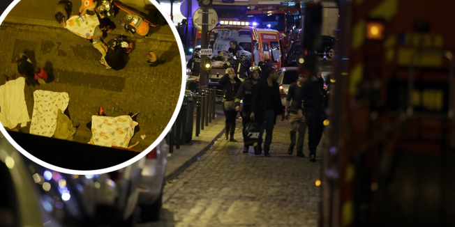 Security moves people along Rue Bichat following a string of attacks in the French capital Paris on November 13, 2015. At least 18 people were killed as multiple shootings and explosions hit Paris Friday, police said. Police also said there was an ongoing hostage crisis in the Bataclan a concert hall in the French capital. AFP PHOTO / KENZO TRIBOUILLARD