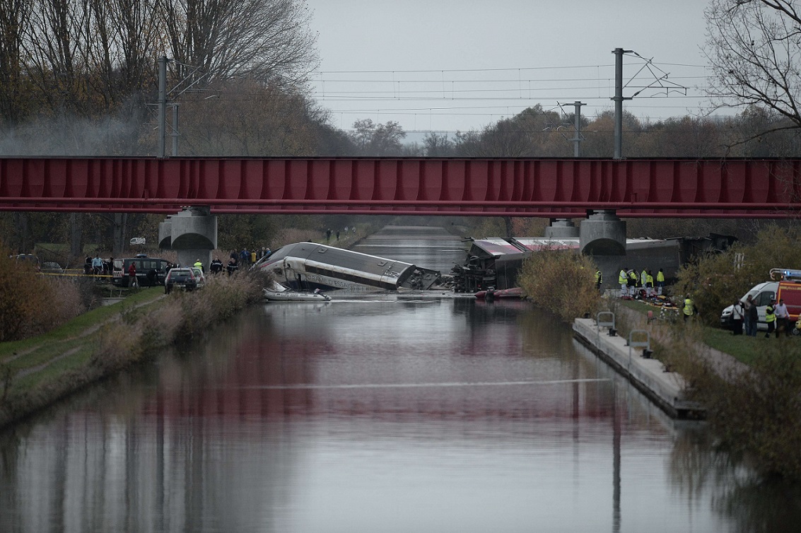 A high-seepd TGV train coach and engine carriage lie in a canal in Eckwersheim near Strasbourg, northeastern France, after derailing on November 14, 2015 during tests conducted by technicians, Frenh railway operator SNCF said. At least five were killed in French high-speed train test on November 14, due to excessive speed, sources said. AFP PHOTO / FREDERICK FLORIN