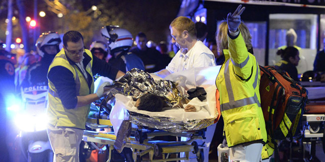 TOPSHOTSRescuers evacuate an injured person near the Bataclan concert hall in central Paris, early on November 14, 2015. At least 120 people were killed in a series of terror attacks in Paris on November 13 according to a provisional total, a source close to the investigation said. AFP PHOTO / MIGUEL MEDINA