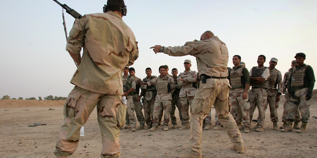 FALLUJAH, IRAQ - JULY 26:  A U.S. Navy SEALS show proper weapons handling to Iraqi army scouts July 26, 2007 in Fallujah, Iraq. The SEALS are training Iraqi forces on advanced combat techniques as part of the American effort to build up the Iraqi military.  (Photo by John Moore/Getty Images) 