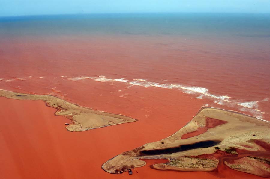 Handout picture released by the Espirito Santo State Press Office showing an aerial view of the Doce River--which was flooded with toxic lama after a dam owned by Brazilian Vale SA and Australian BHP Billiton Ltd burst early this month-- flowing into the Atlantic Ocean in Regencia, Espirito Santo State, Brazil, on November 24, 2015. AFP PHOTO/Espirito Santo State Press Office - FRED LOUREIRO