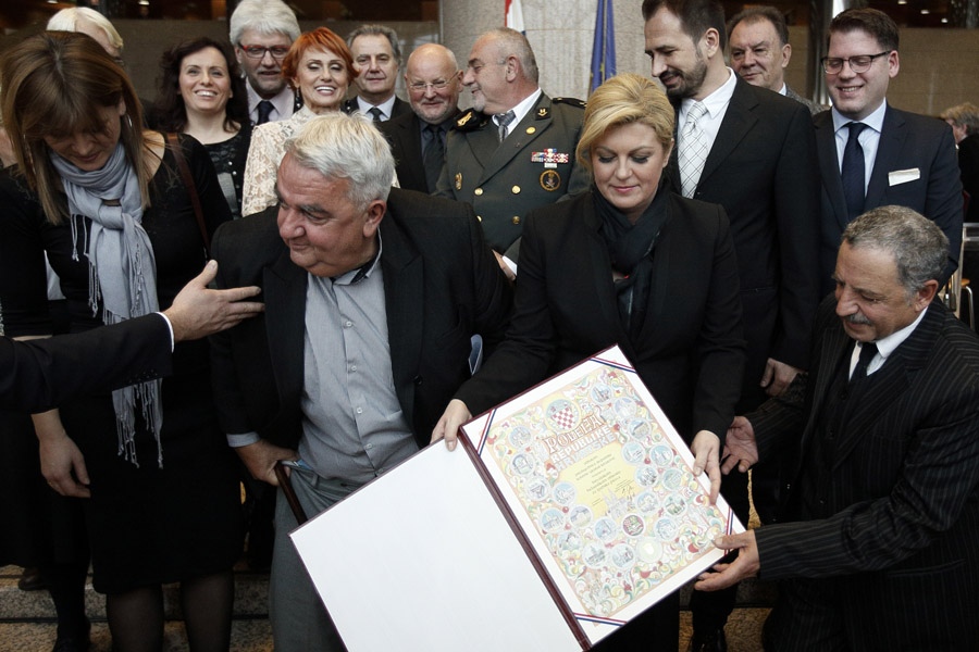 Zagreb, 081215.Povodom Medjunarodnog dana ljudskih prava u NSK odrzana svecana dodjela nagrada Hrvatskog helsinskog odbora HHO za ljudska prava.Na fotografiji: prilikom snimanja zajednicke fotografije clanova HHO-a s predsjednicom Kolindom Grabar Kitarovic, doslo je do male nezgode, predsjednik HHO-a Ivan Zvonimir Cicak ostao je na trenutak bez hlaca.Foto: Dragan Matic / CROPIX