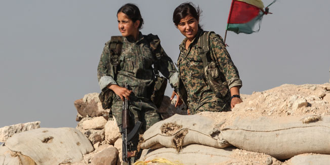KOBANE, SYRIA - JUNE 20: (TURKEY OUT) A Kurdish People's Protection Units, or YPG women fighters pose as they stand near a check point in the outskirts of the destroyed Syrian town of Kobane, also known as Ain al-Arab, Syria. June 20, 2015. Kurdish fighters with the YPG took full control of Kobane and strategic city of Tal Abyad, dealing a major blow to the Islamic State group's ability to wage war in Syria. Mopping up operations have started to make the town safe for the return of residents from Turkey, after more than a year of Islamic State militants holding control of the town. (Photo by Ahmet Sik/Getty Images)