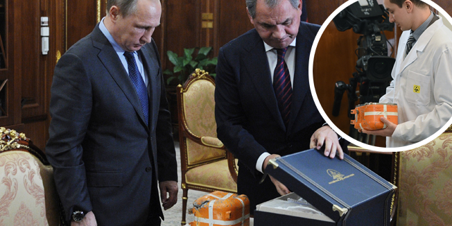 Russian President Vladimir Putin (L) and Defence Minister Sergei Shoigu examine at the Novo-Ogaryovo residence outside Moscow on December 8, 2015, the flight recorder from the Russian Sukhoi Su-24 bomber which was shot down by a Turkish jet on November 24. Moscow and Ankara are locked in their worst crisis since the Cold War over the November 24 downing of a Russian jet on Turkey's border with Syria, sparking fury and economic sanctions from the Kremlin. / AFP / SPUTNIK / MIKHAIL KLIMENTYEV